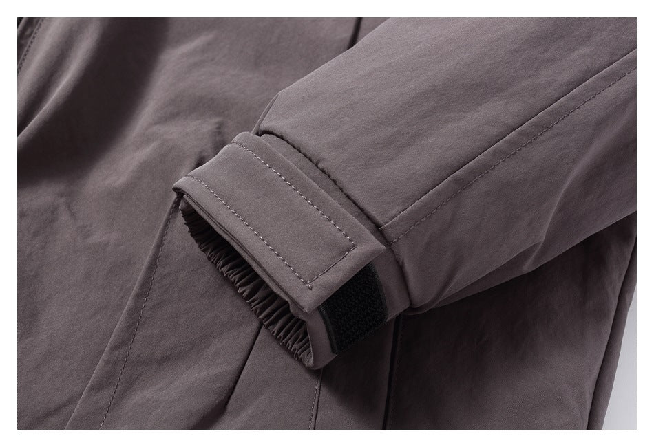 Close-up of a dark gray jacket sleeve cuff with an adjustable hook-and-loop tab.