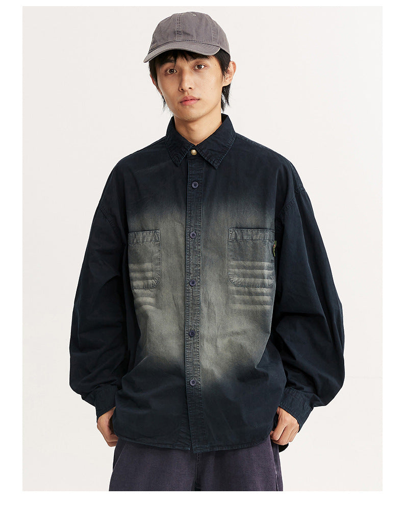 Front view of a model wearing an oversized black shirt with a faded gray chest and two patch pockets.