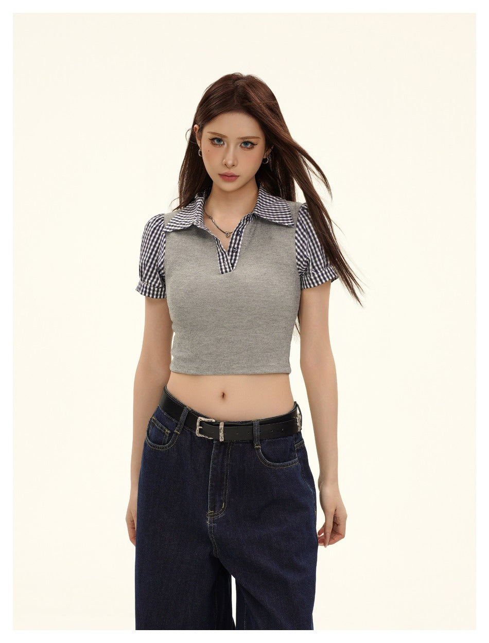 Closer front view of a model wearing a gray cropped top with a gingham collar, button placket, and puff sleeves.