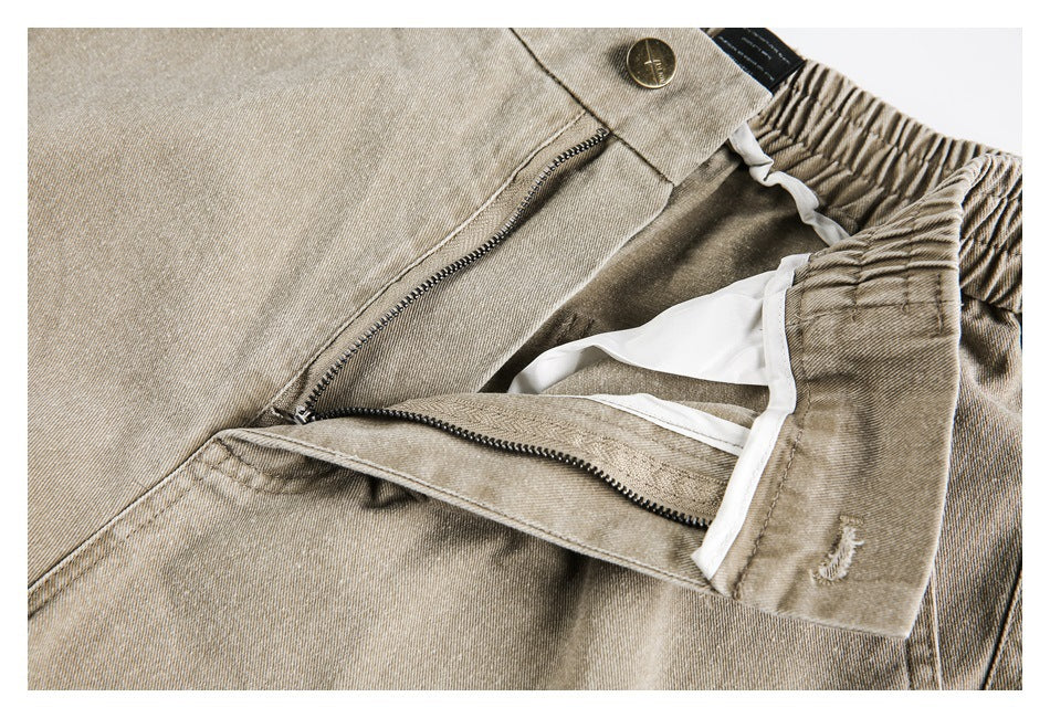 Close-up of beige pants with the button and zipper open, showing the inner waistband and lining.