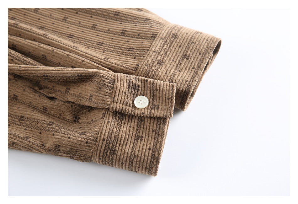 Close-up of the tan shirt's buttoned cuff and sleeve, showing its dark vertical pattern.