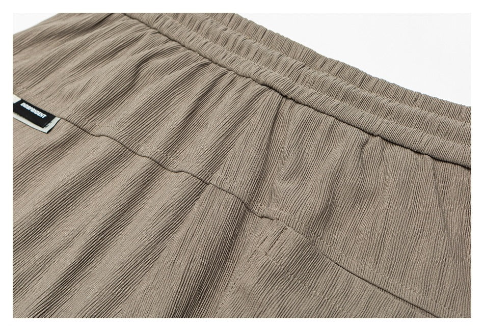 Close-up of taupe pants showing the elastic waistband and interior seam.