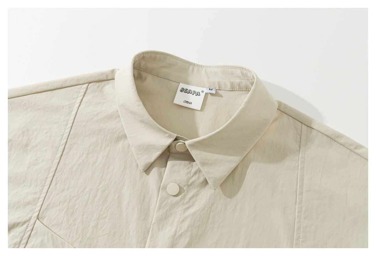 Close-up of an ivory shirt-jacket collar, large front snaps, and a visible neck label.