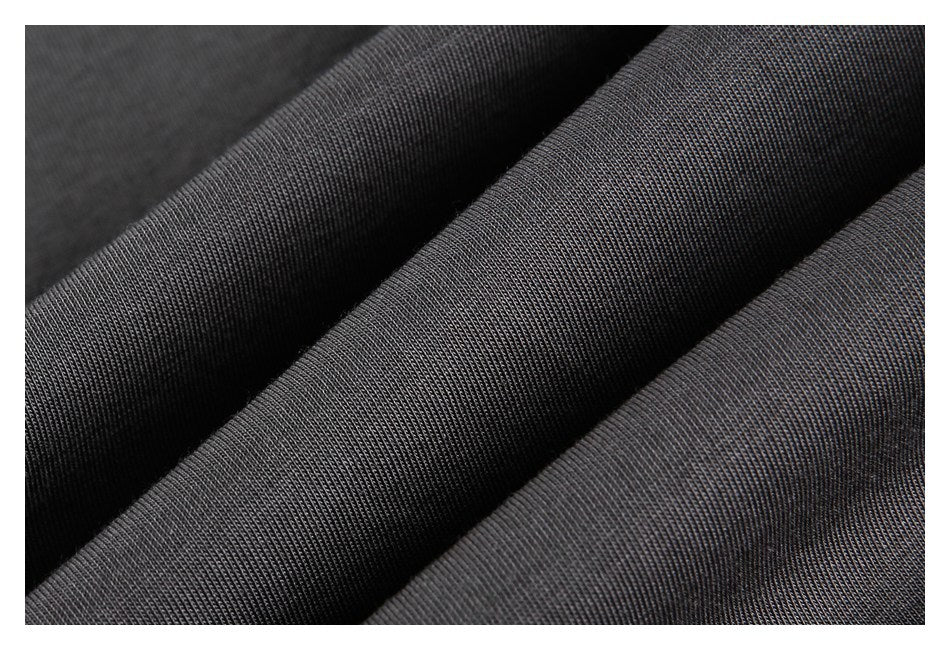 Macro view of charcoal fabric folded into ridges, showing its fine knit texture.