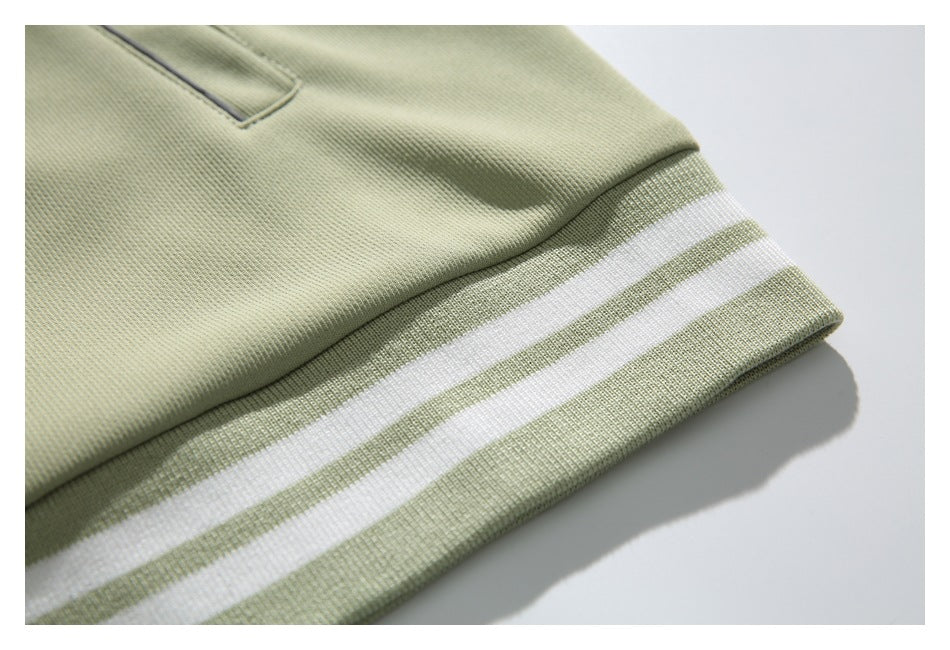 Close-up of the pale sage jacket's ribbed hem with two white stripes.