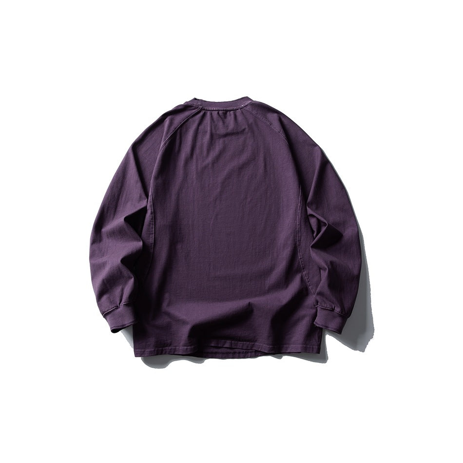 Back view of a dark purple long-sleeve crewneck shirt with raglan sleeves and ribbed cuffs.