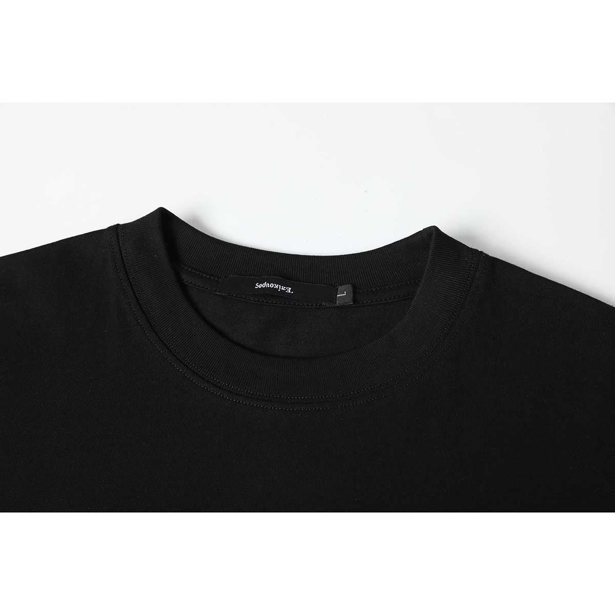 Close-up of a black T-shirt's ribbed crew neck, shoulder seams, and inner neck label.