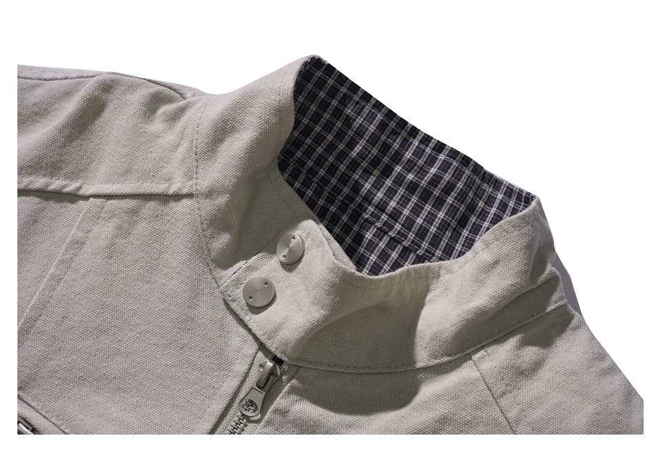 Close-up of the jacket’s raised collar, plaid lining, two buttons, and zipper.