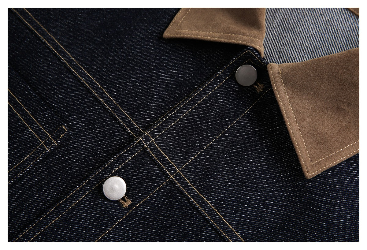 Close-up of dark indigo denim with tan stitching, metal buttons, and a brown contrast collar.