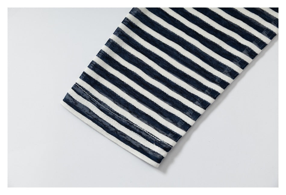 Close-up of a navy and cream striped sleeve ending in a plain cream hem.