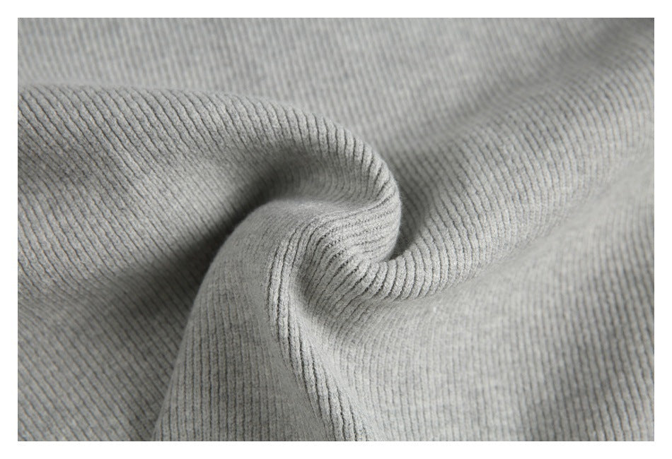 Close-up of light gray ribbed knit fabric gathered into a soft fold.