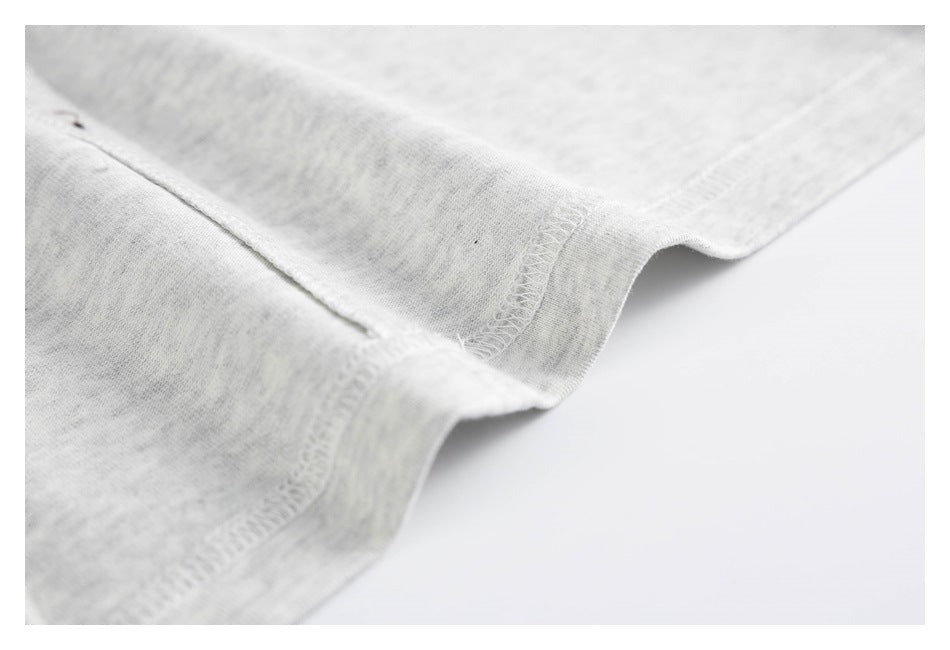 Close-up of a light gray heather shirt's stitched edge and overlock seam.