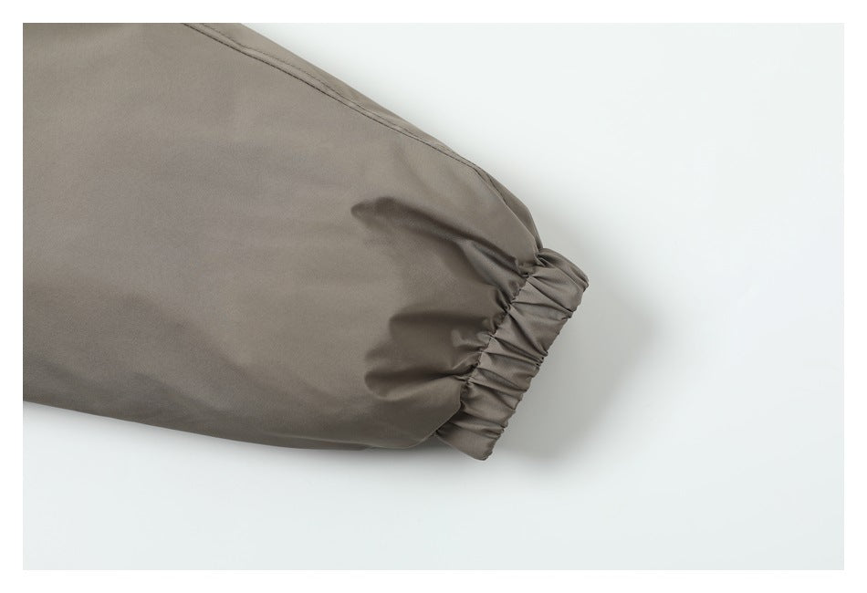 Close-up of the taupe jacket sleeve ending in a gathered elastic cuff.