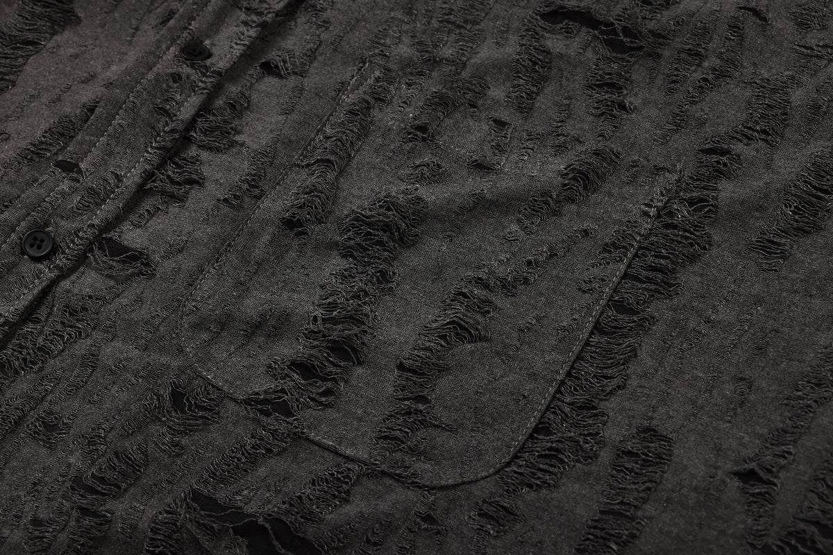 Close-up of a charcoal shirt patch pocket and button placket amid distressed textured stripes.