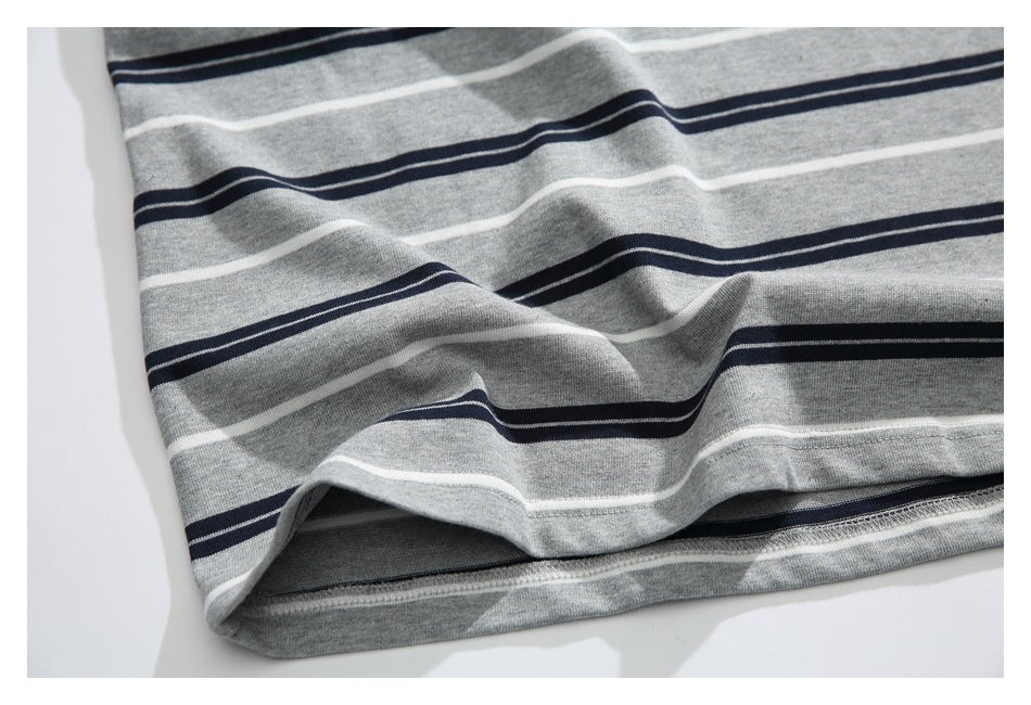 Close-up of the hem and stitching on gray fabric with horizontal navy and white stripes.