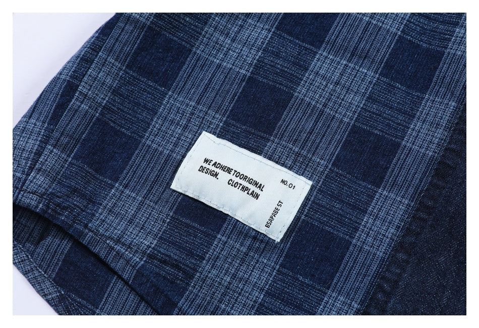Close-up of a sewn English text label on navy fabric with a light blue plaid pattern.