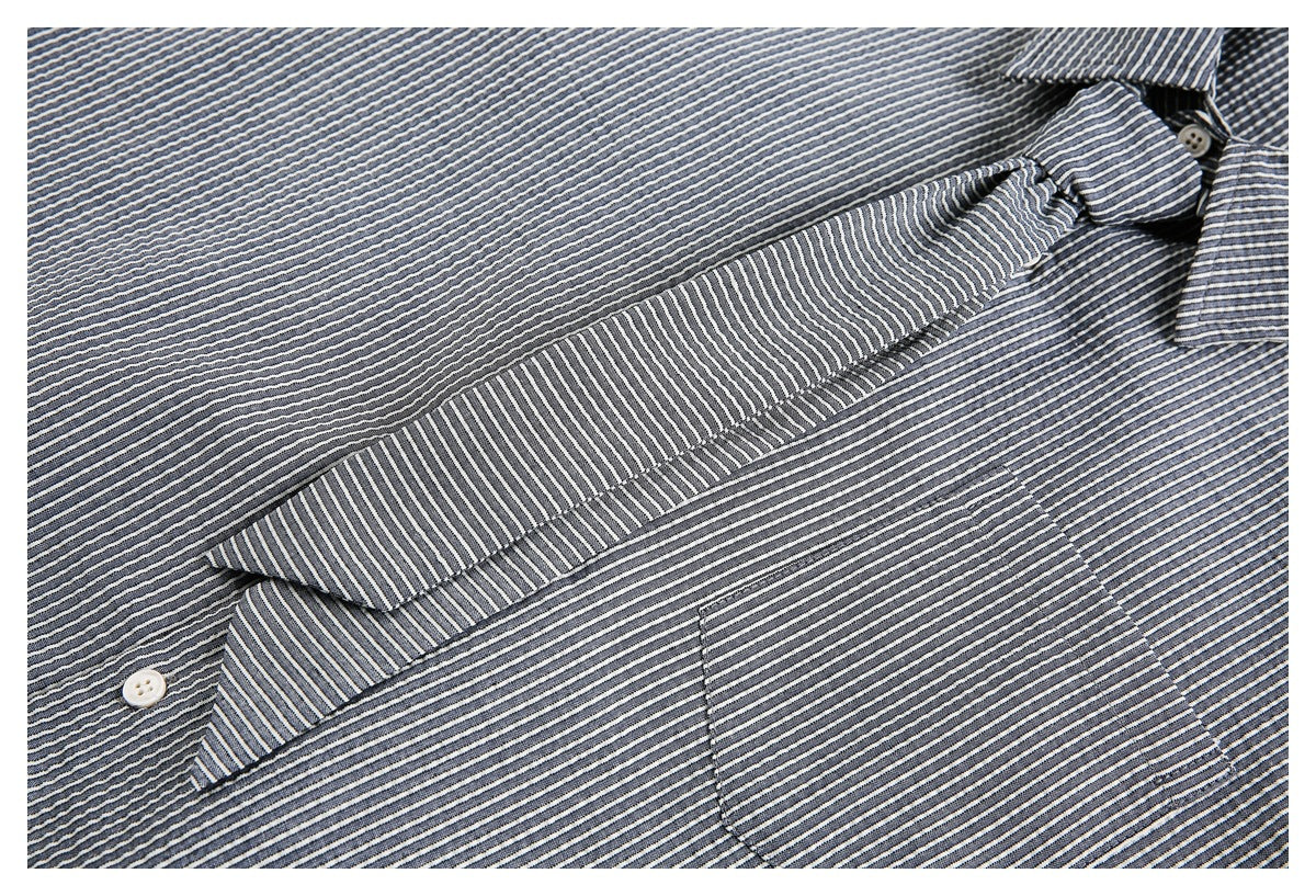 Close-up of the striped shirt's collar, button placket, and chest pocket.