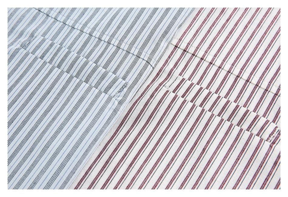 Close-up of blue-gray and burgundy striped shirt fabric showing stitched pocket details.