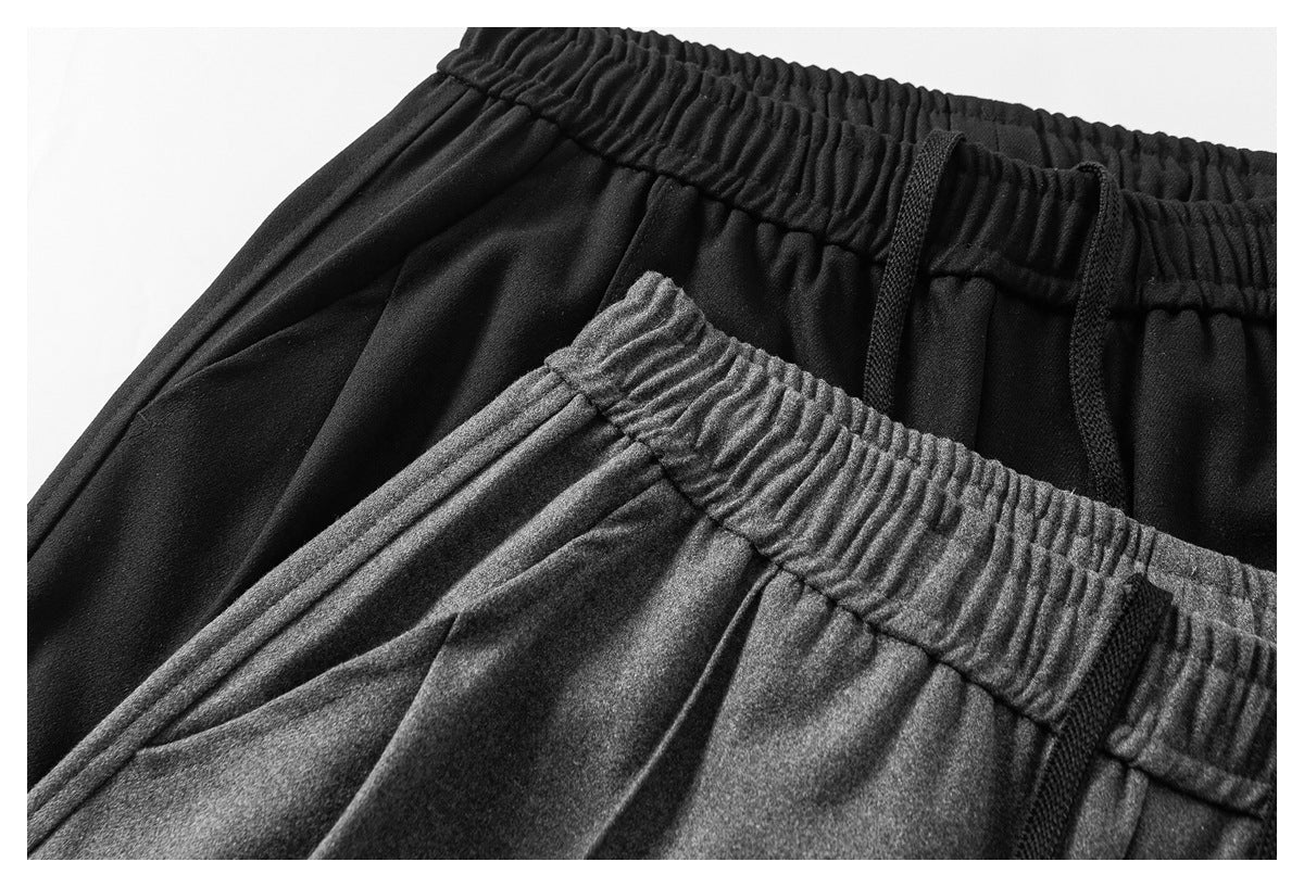 Close-up of black and charcoal-gray pants showing elastic waistbands and black drawstrings.