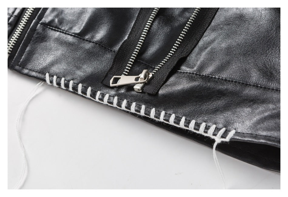 Close-up of a black jacket with silver zippers and thick white stitching along the edge.