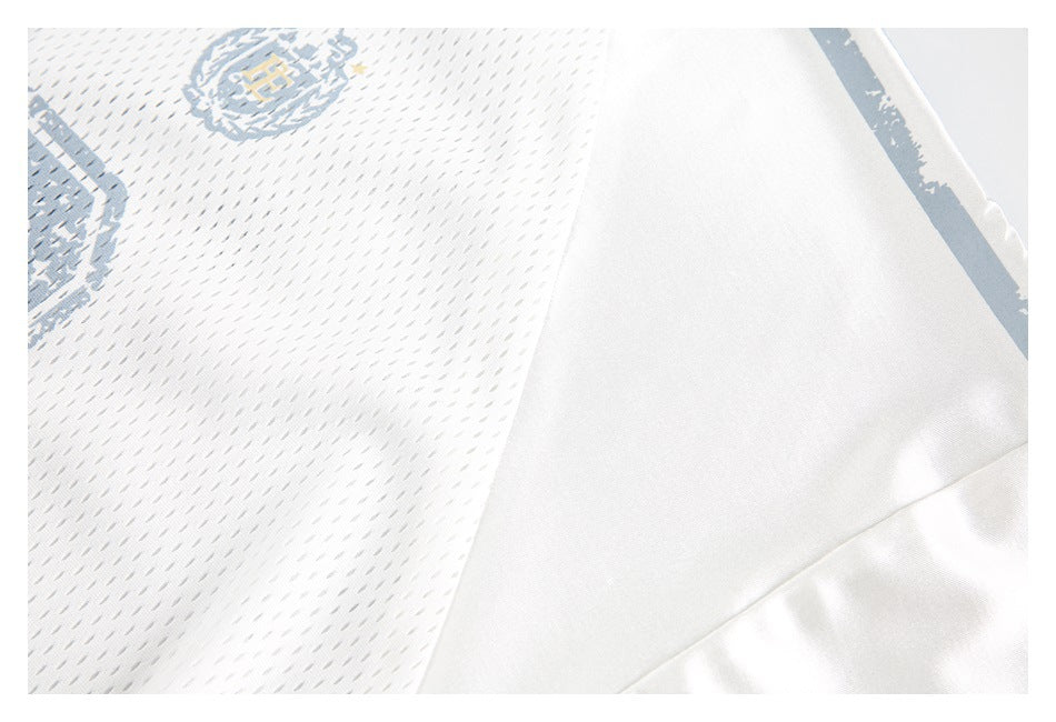 Close-up of a white jersey showing perforated mesh, a smooth side panel, and a pale blue-gray stripe.