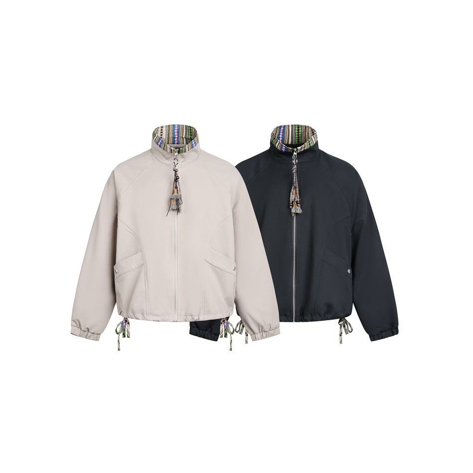 Two front-view cropped zip jackets with patterned stand collars, shown in light taupe and black.
