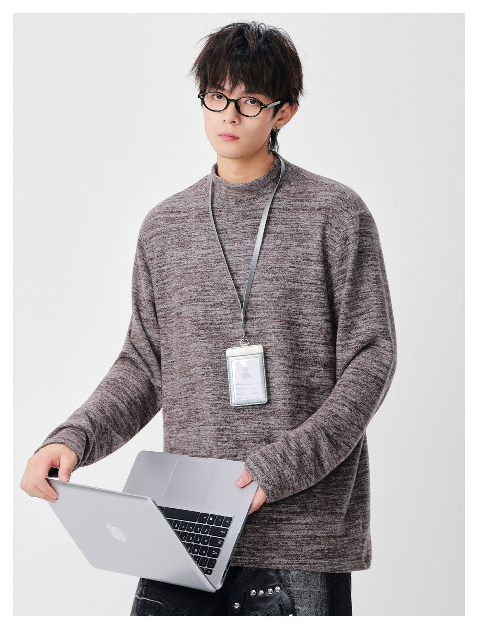 Model wearing a taupe-gray marled long-sleeve top with a high round neckline.