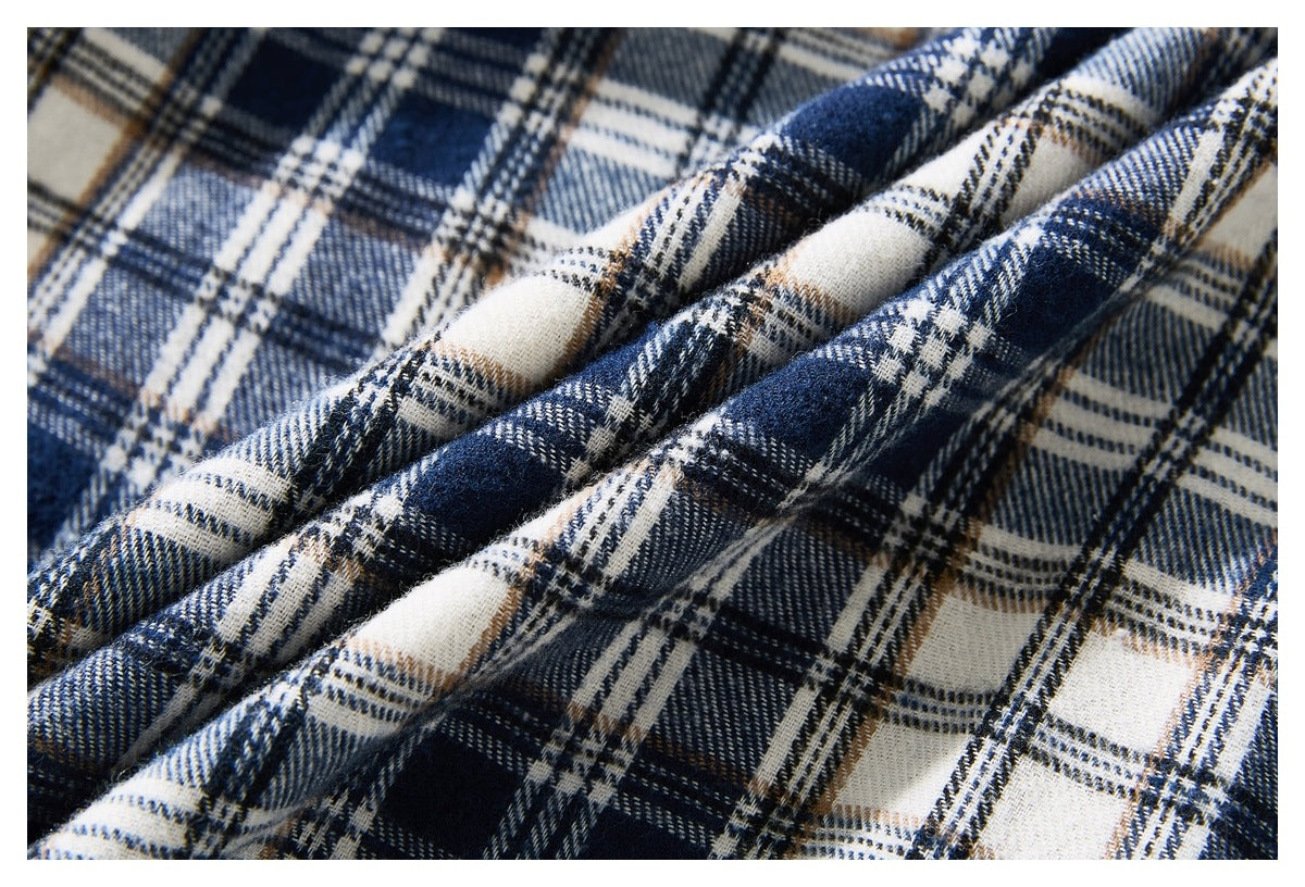 Close-up of navy, cream, gray, and tan plaid fabric arranged in soft folds.