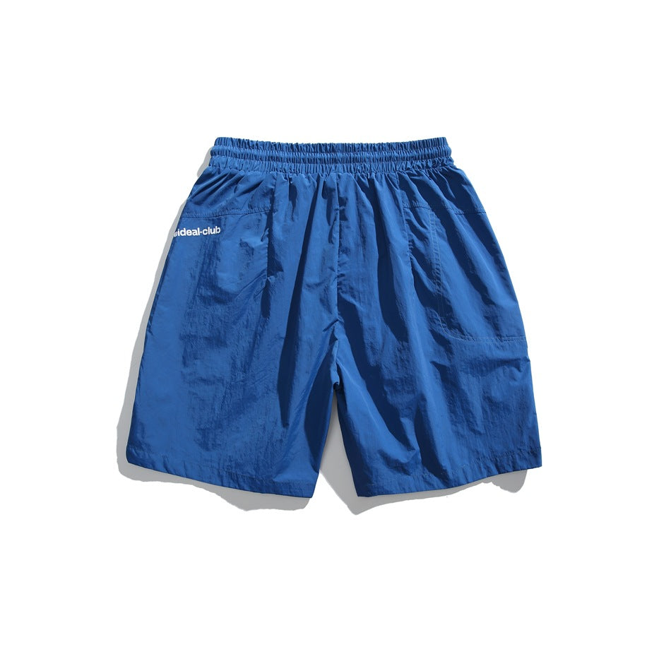 Royal blue shorts back view with elastic waistband and small printed text on the side