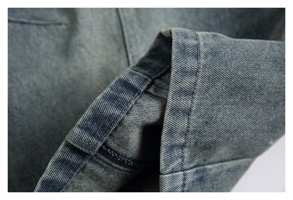 Close-up of a folded denim pant leg showing the hem stitching and inner seam.