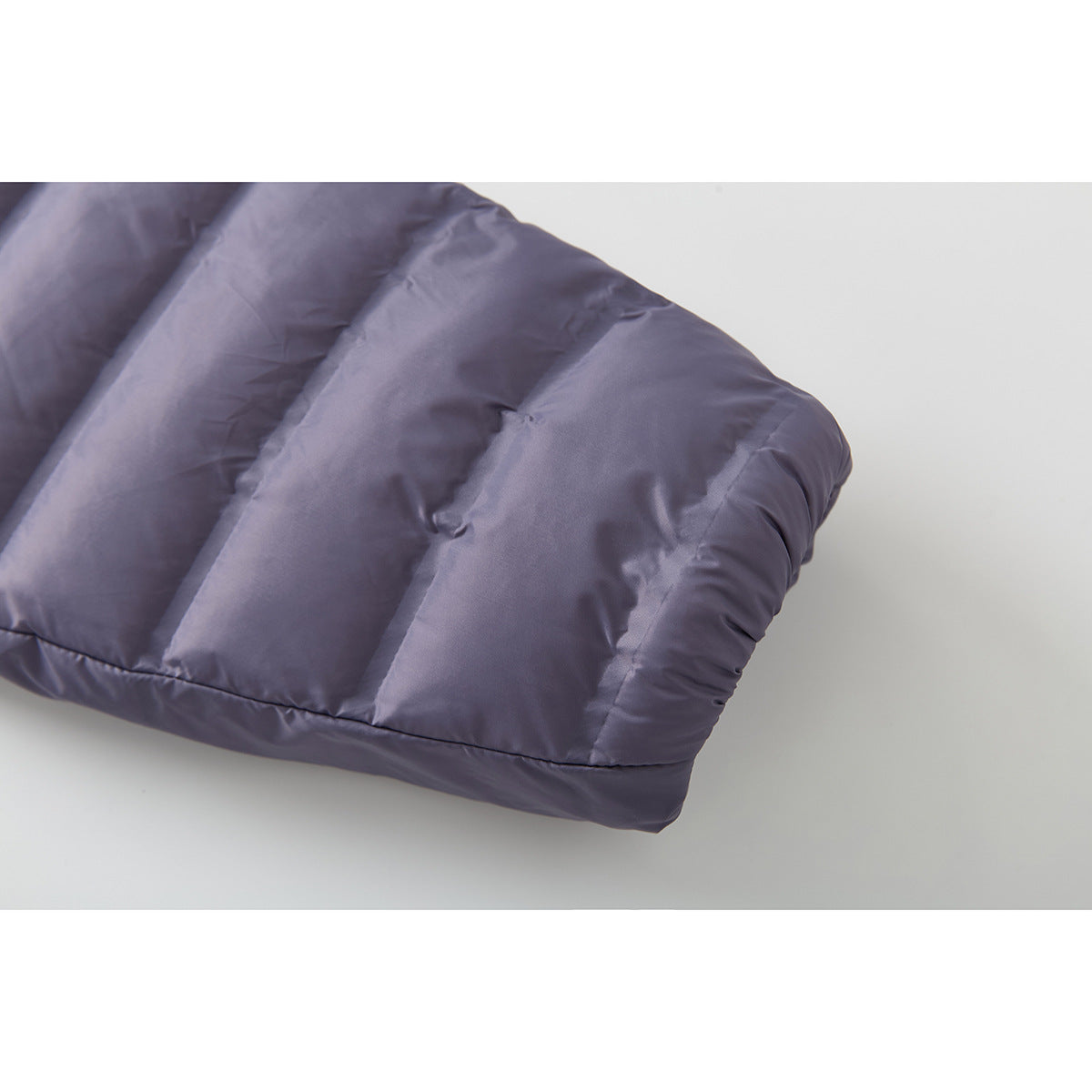 Close-up of the lavender-gray jacket's padded sleeve and stitched quilting.