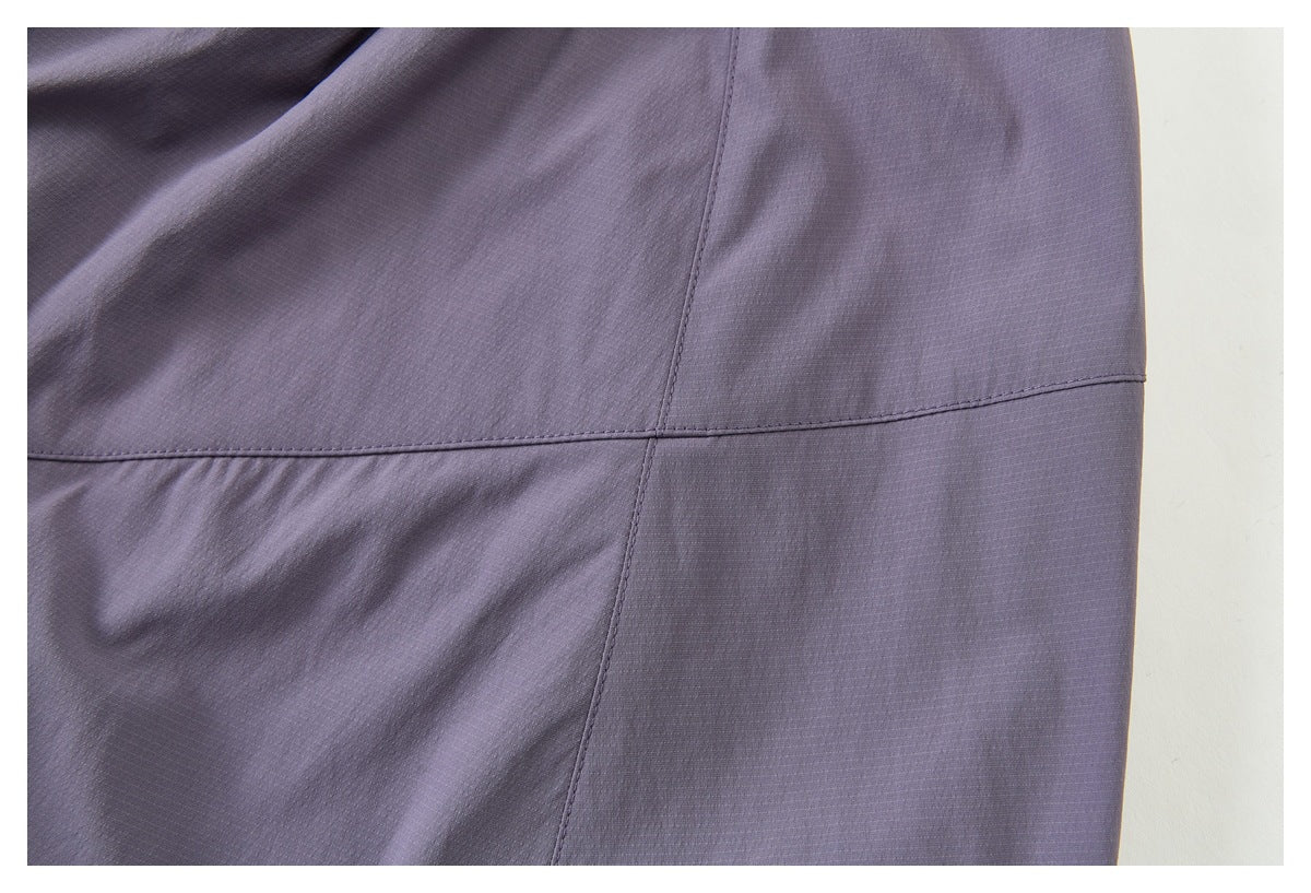 Close-up of muted lavender-gray garment fabric with intersecting stitched seams.