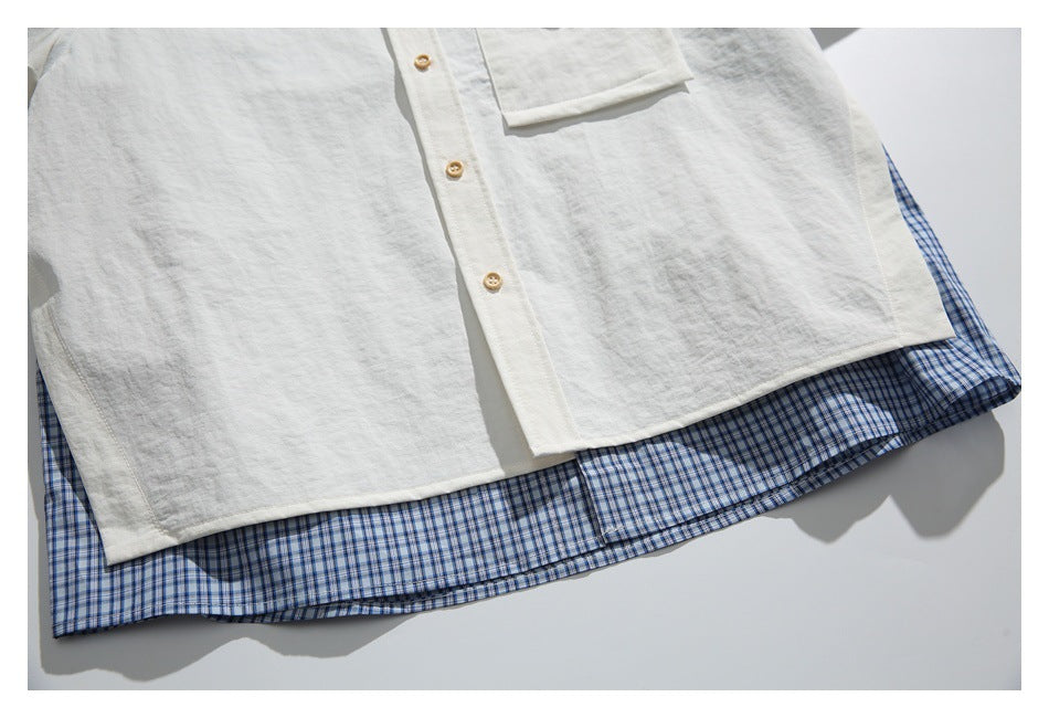 Close-up of the off-white shirt hem layered over blue checked fabric.