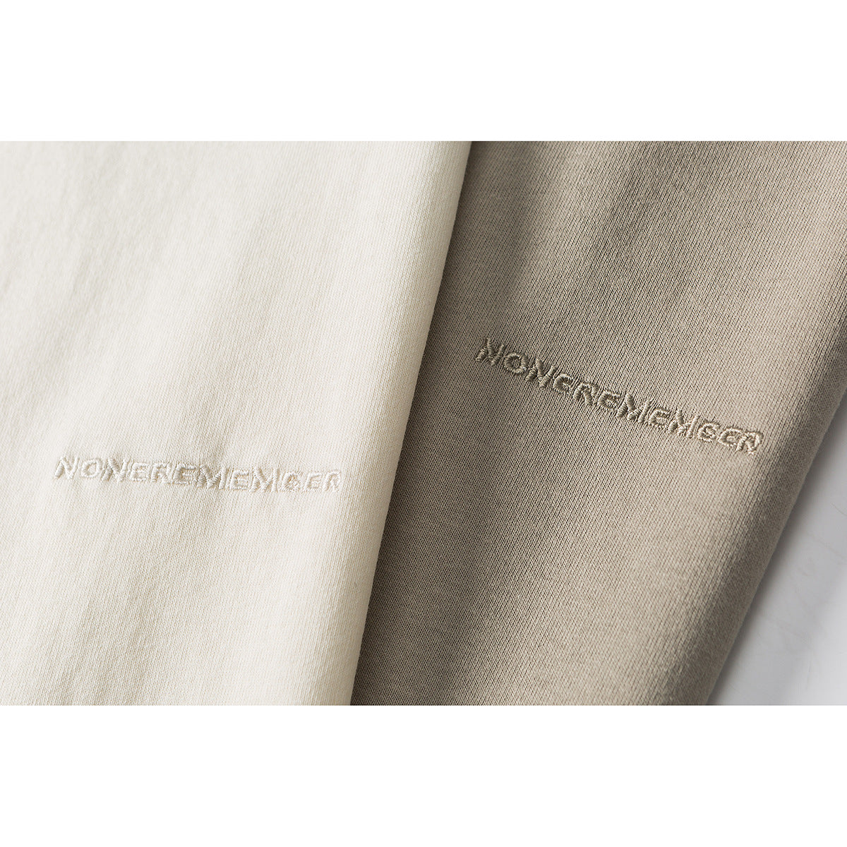 Close-up of cream and taupe fabric panels with small tonal embroidered lettering.