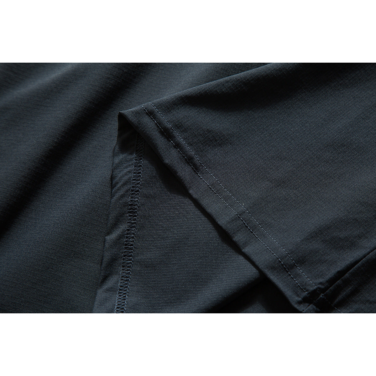 Close-up of the dark shirt's sleeve and interior overlock stitching.