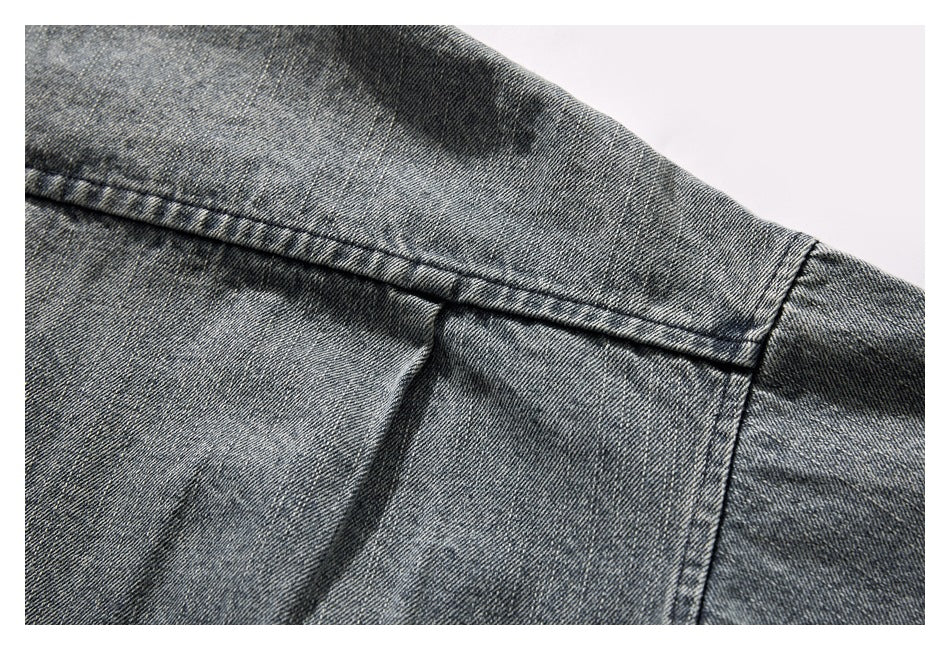 Close-up of the denim jacket's back shoulder seam and sleeve attachment.