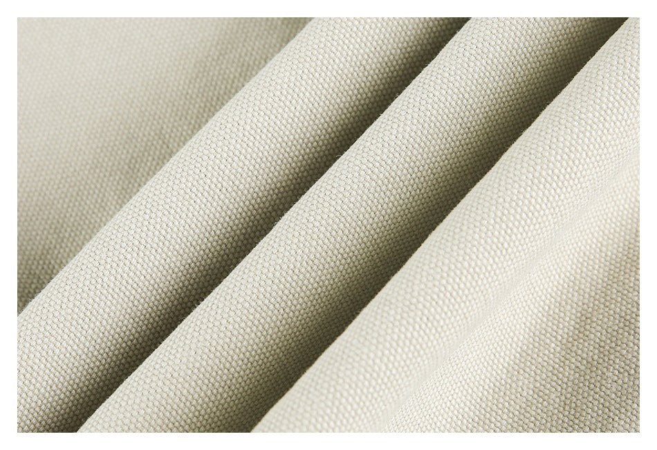 Macro view of the textured weave of light beige fabric arranged in folds.