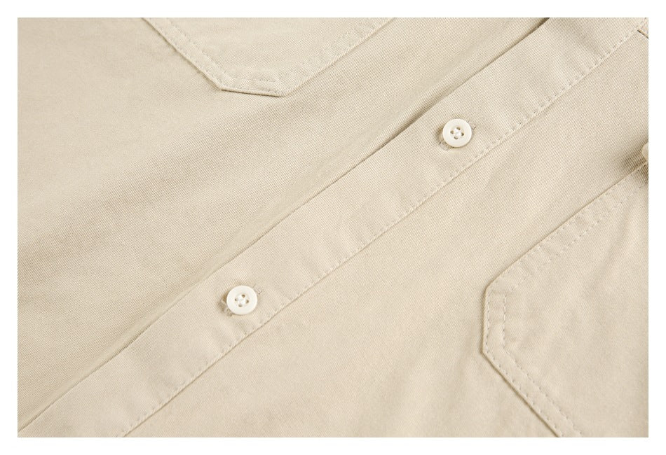 Close-up of the beige shirt placket with white buttons and part of a chest pocket.
