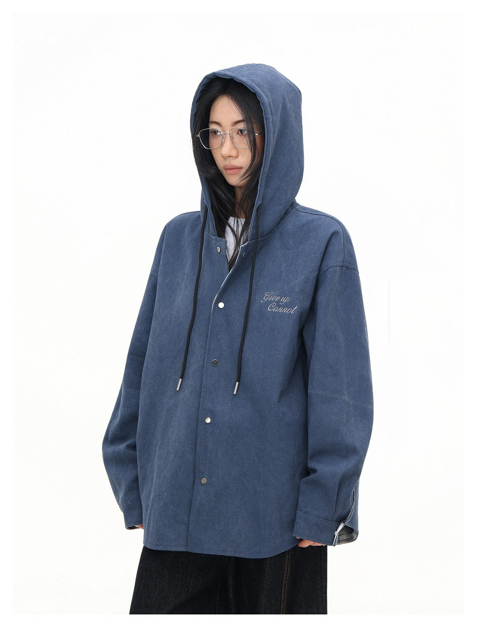 Model wearing a dark blue hooded overshirt with snap buttons, drawstrings and small script embroidery on the chest.