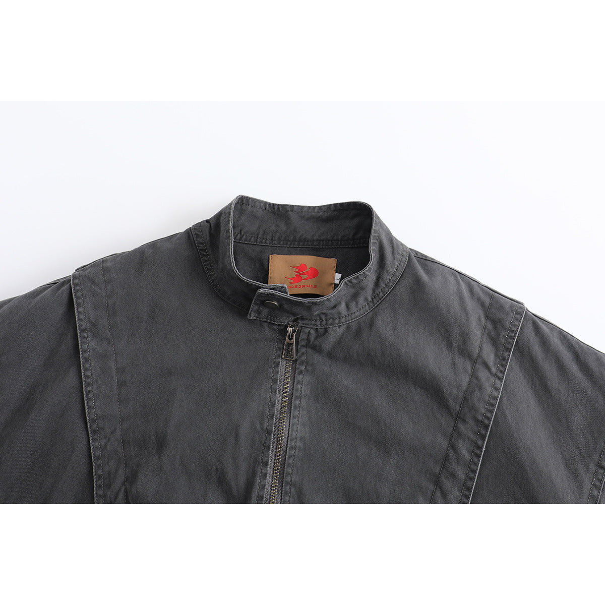 Close-up of a charcoal jacket's stand collar, front zipper, seam detailing, and inner neck label.