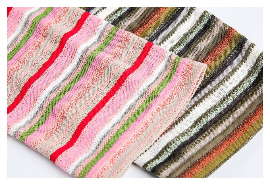 Close-up of overlapping pink and earth-tone striped fabric showing the knit texture and stripes.