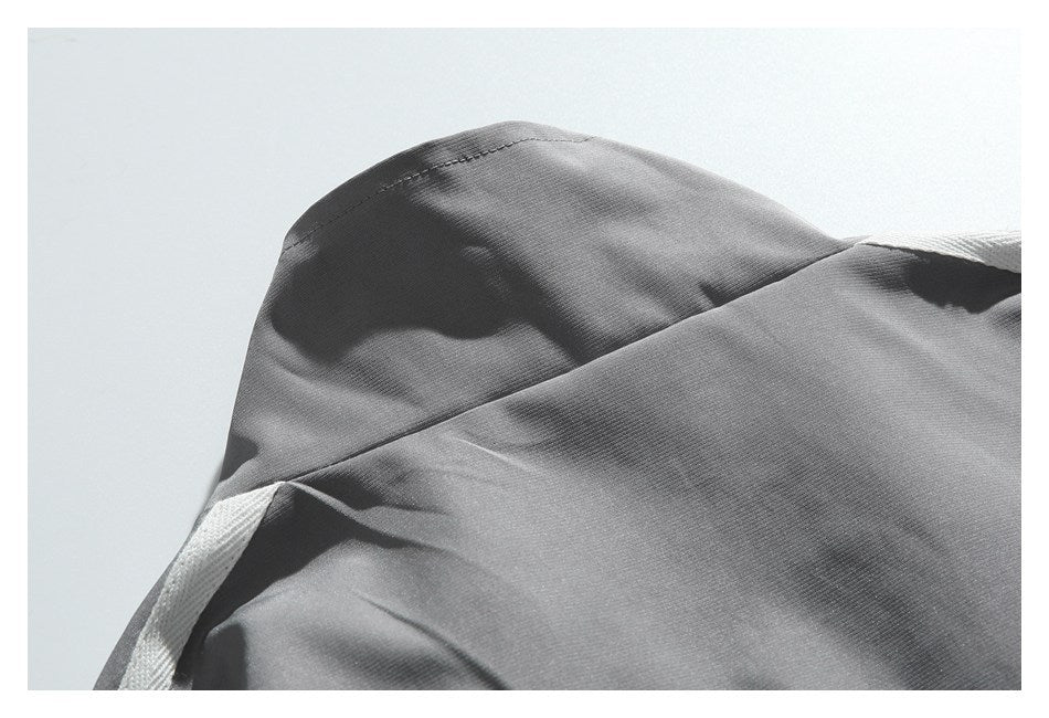 Close-up of charcoal-gray garment fabric with a curved seam and pale edging.