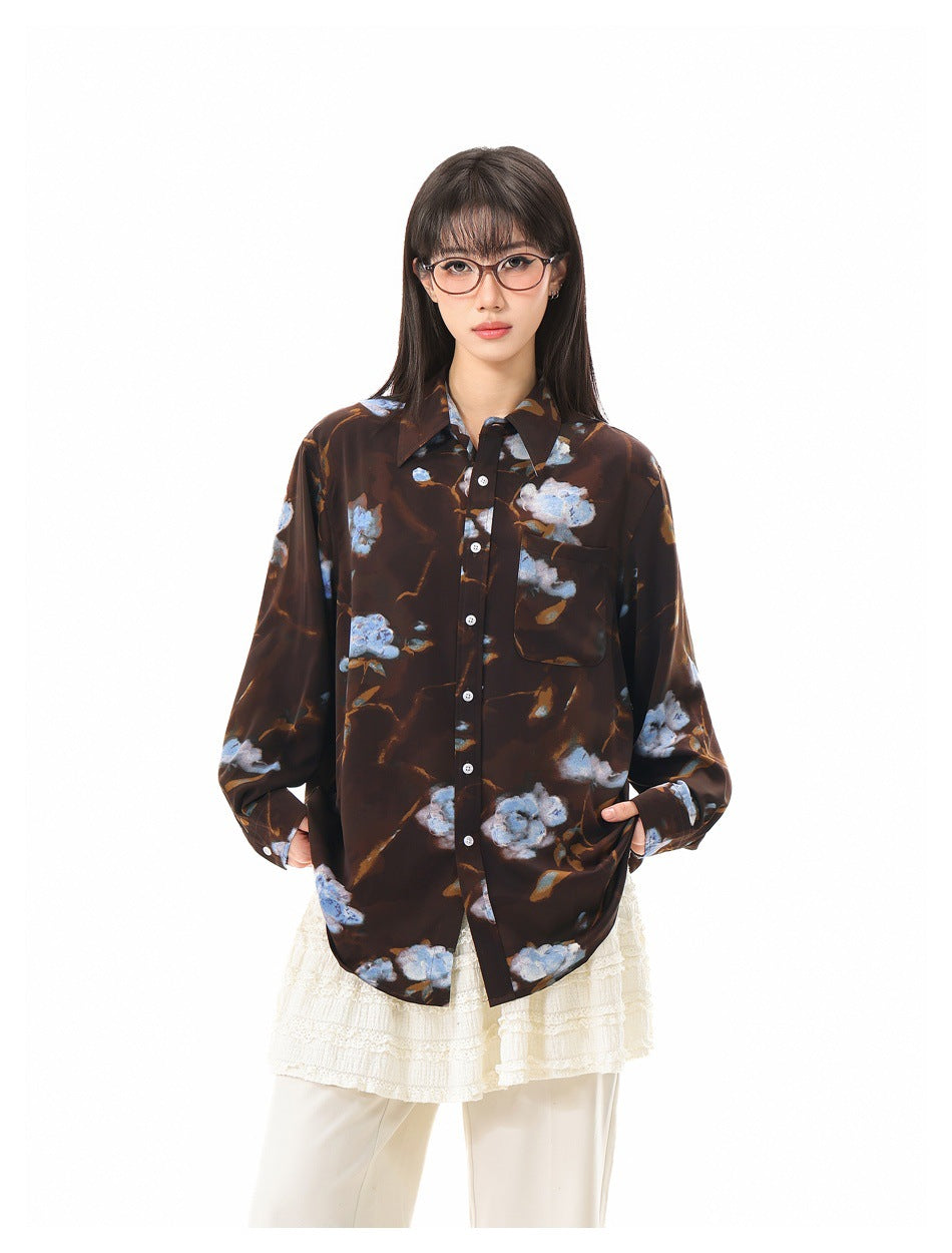 Front view of a model wearing a dark brown oversized shirt with blue floral print and a chest pocket.