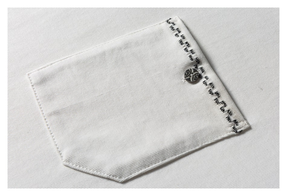 Close-up of a white shirt pocket with a metallic button and black decorative edge stitching.