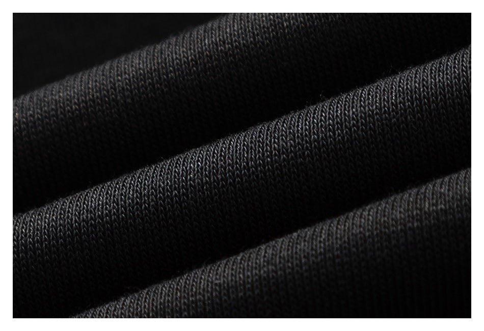 Macro view of the black garment's knit surface, showing rows of stitches and folded fabric.