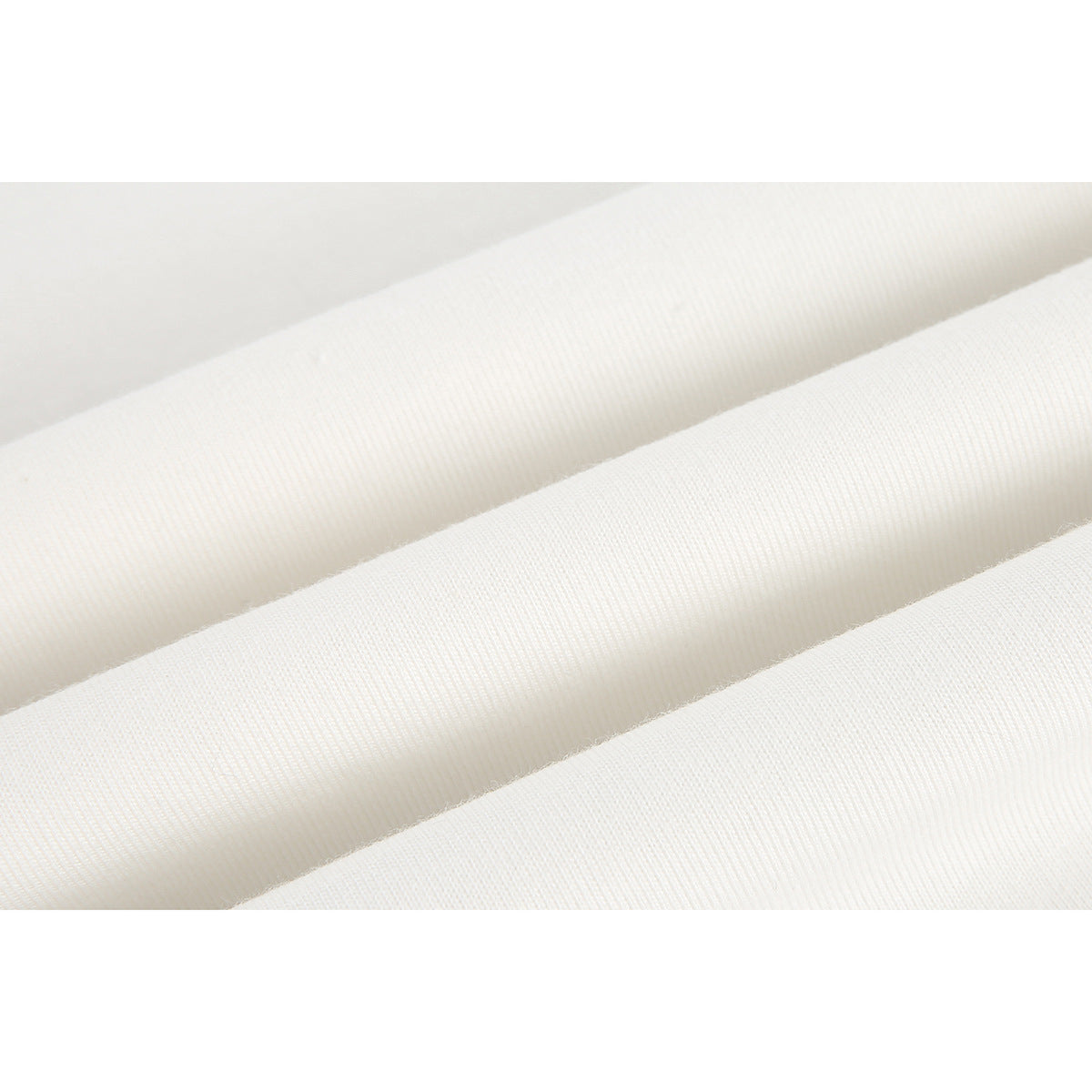 Close-up of off-white fabric arranged in soft folds, showing a fine ribbed texture.