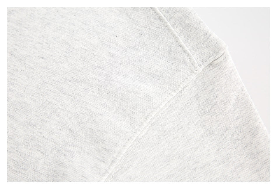 Close-up of a diagonal seam on light gray heathered sweatshirt fabric.