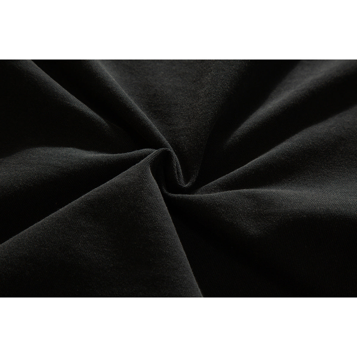 Close-up of dark charcoal shirt fabric gathered into folds.