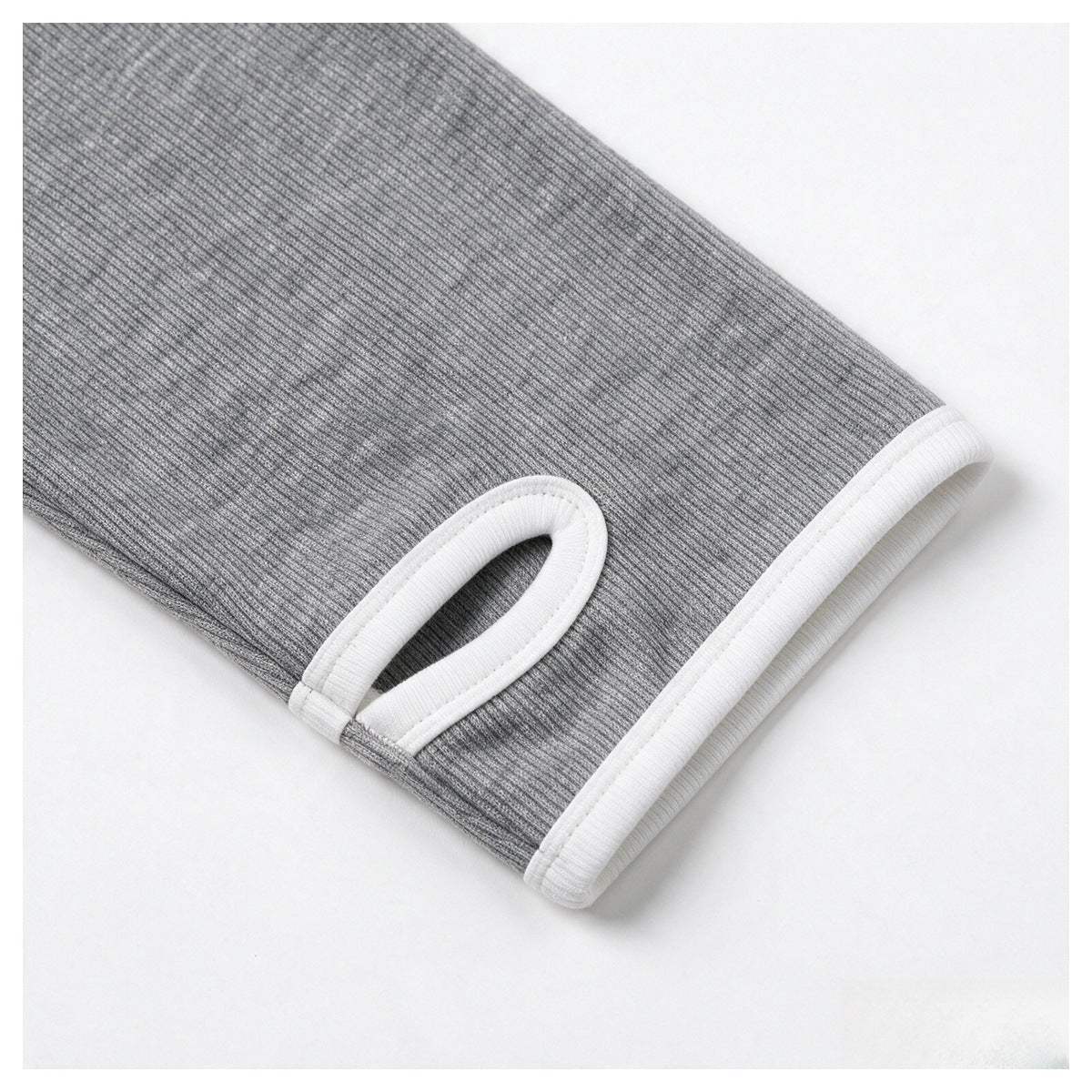 Close-up of a gray ribbed sleeve cuff with white trim and a thumbhole opening.