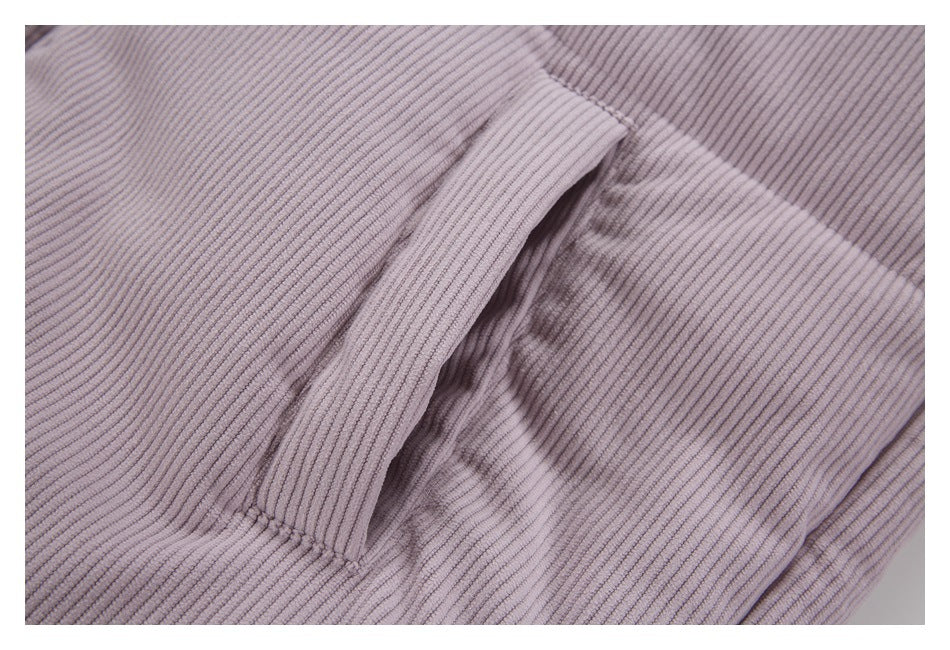 Close-up of a vertical welt pocket on the lilac ribbed jacket.